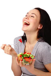 Woman laughing alone with salad1